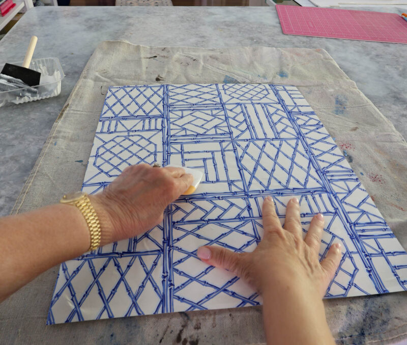 smoothing blue and white wrapping paper on foam board