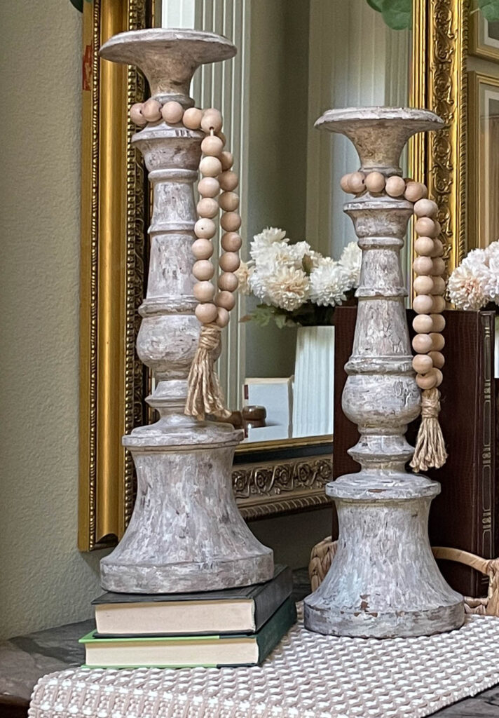 wooden candlesticks on green books