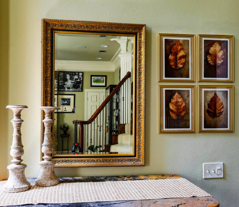 framed leaf prints with mirror and candlesticks on chest