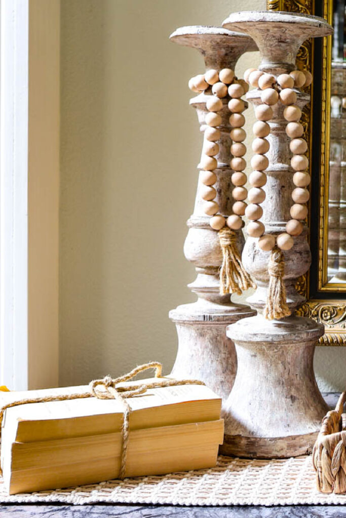 tall vintage wood candlesticks with beads and stacked books
