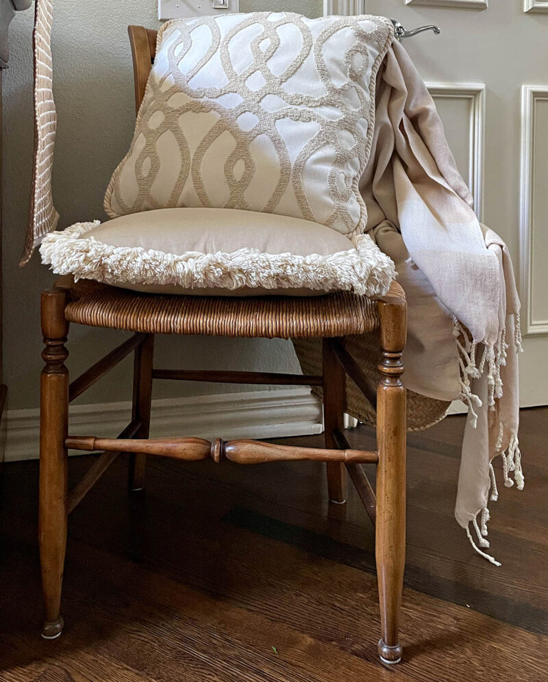 rush chair with neutral pillows, French market tote, and neutral fall throw