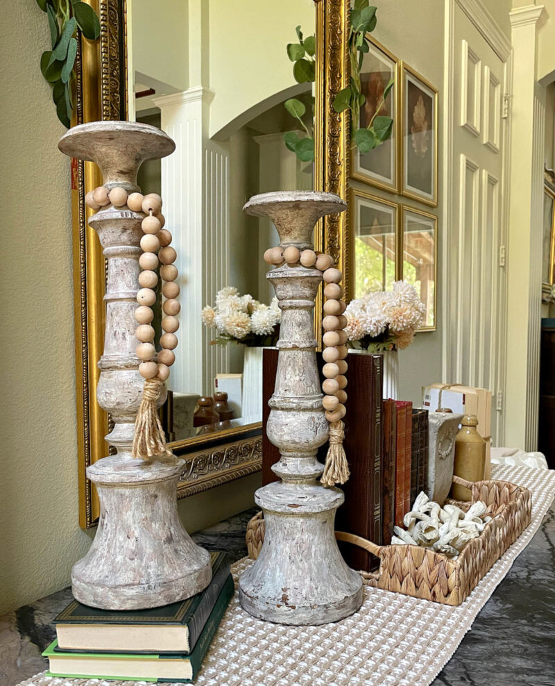 wooden candlesticks on green books