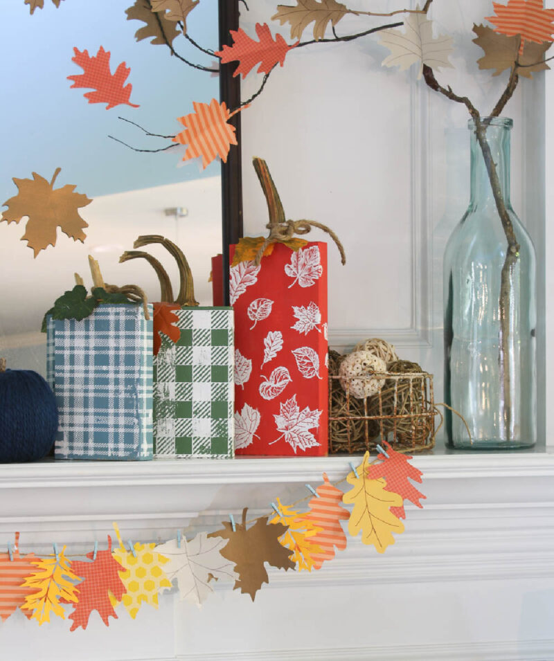 fall mantel decorated with DIY pumpkins and paper leaf trees