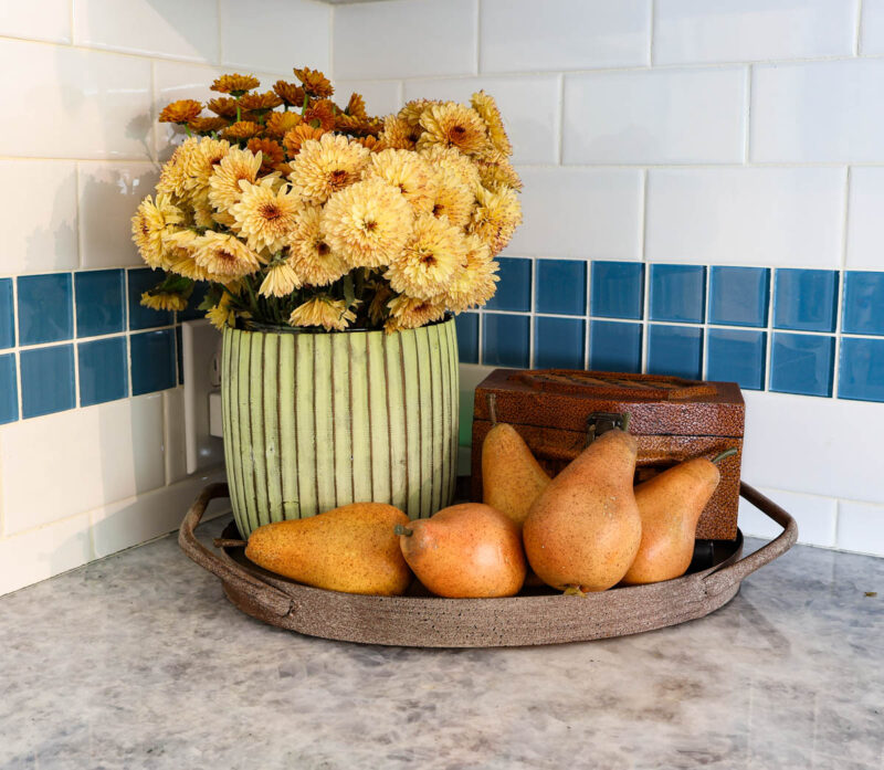 fall arrangement of planter, brown box, and five wood pears on a tray