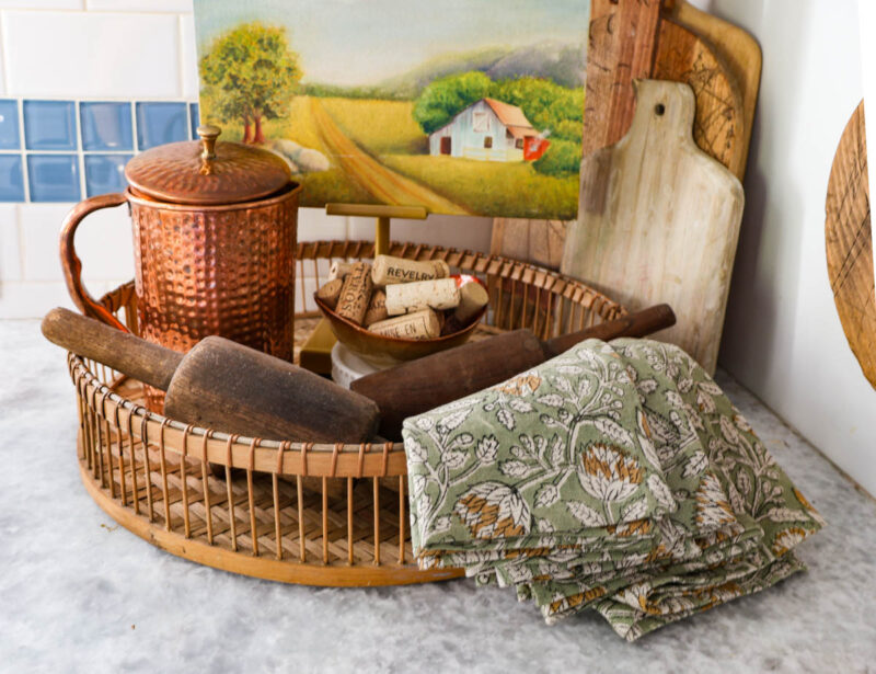 fall decor vignette with copper pitcher, napkins, bowl of wine corks