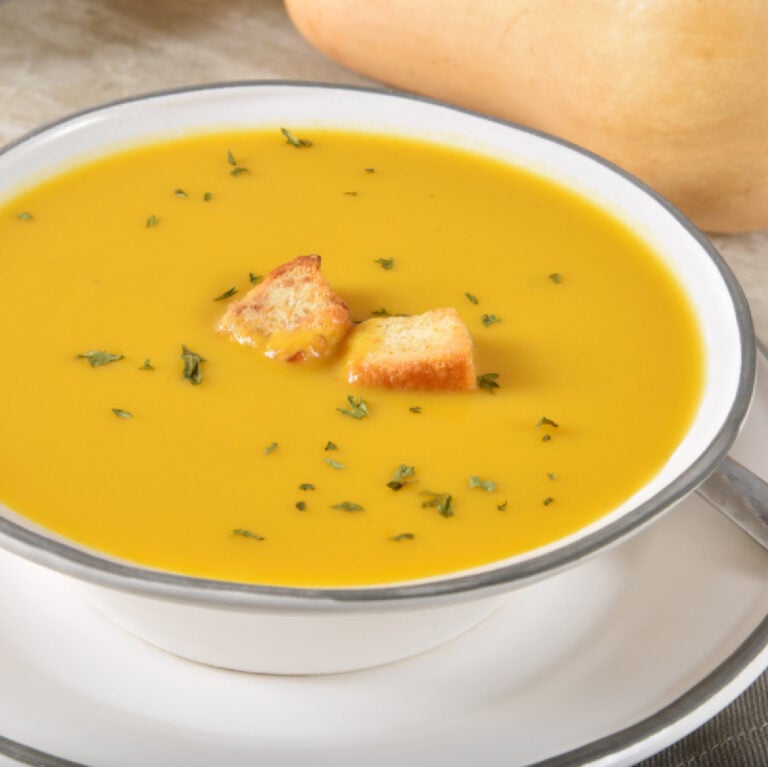 butternut squash with crotons and thyme in white bowl