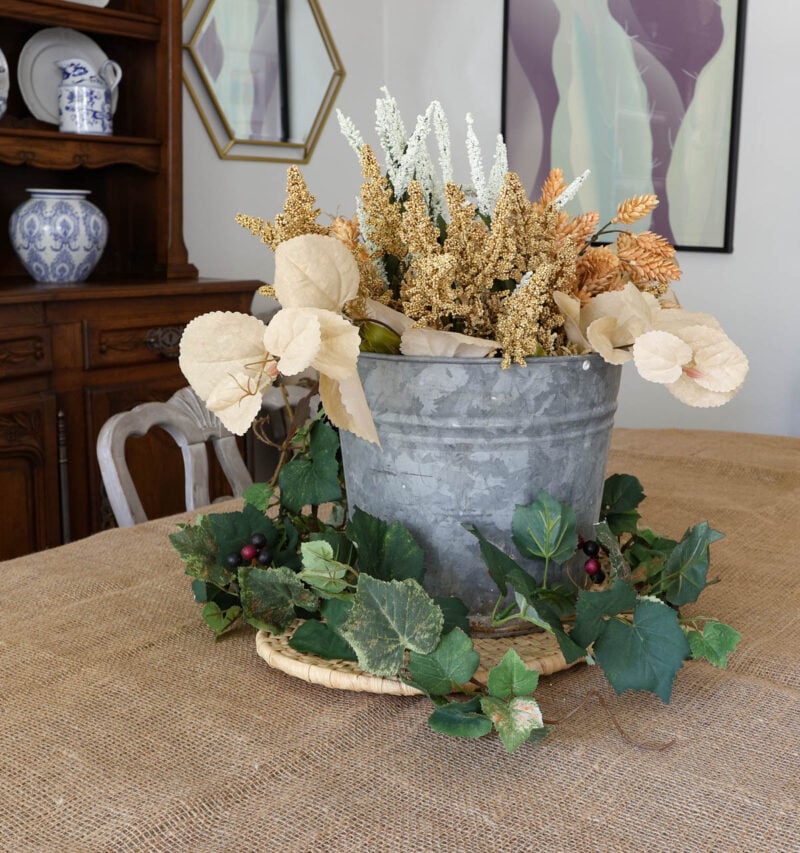 galvanized pail full of fall flowers and foliage on table