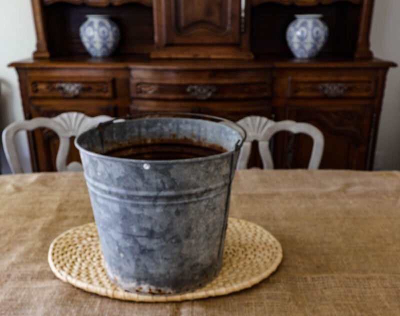 galvanized pail on woven trivet on dining room table