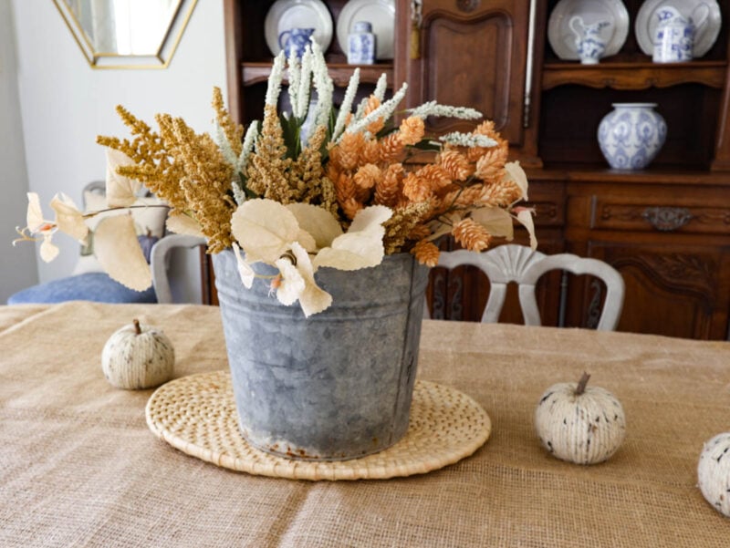 galvanized pail full of fall flowers and foliage on table