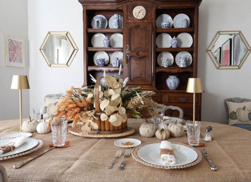 fall table with basket of faux flowers and gold lamps