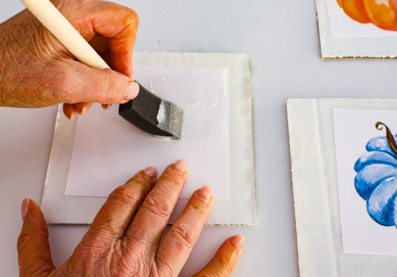 painting cardboard faux tile with Mod Podge on the back