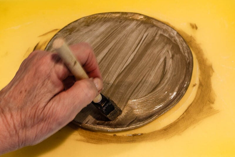 applying first coat of metallic paint to tray